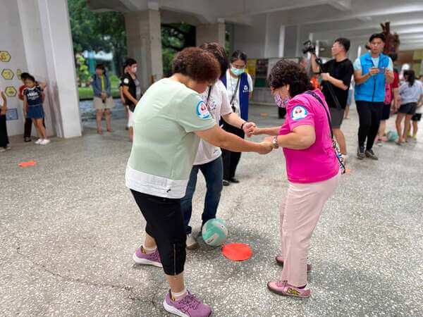由成人一起手牽手共同完成接力競賽：手足之情趣味競賽